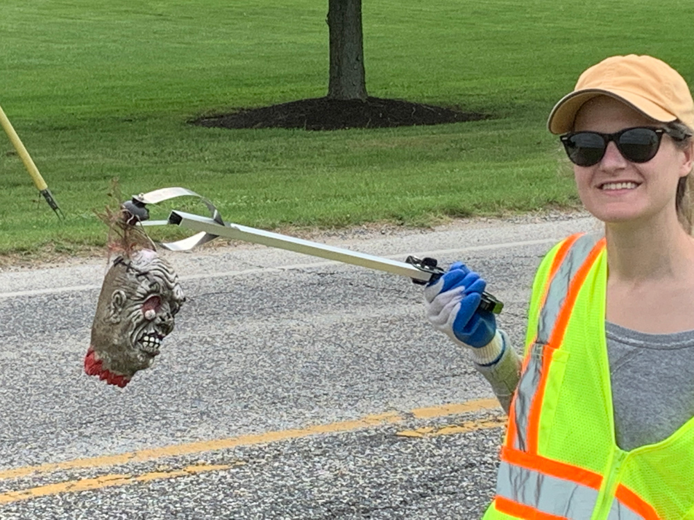 Roadside cleanup lady holding up fake zombie head